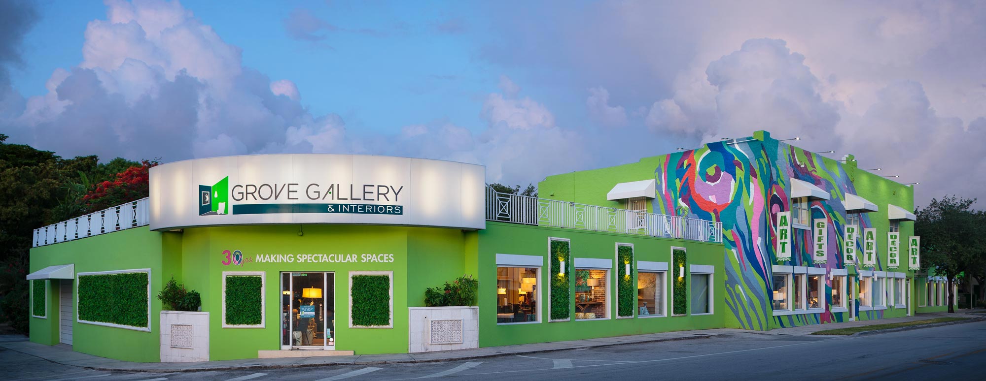 The green Grove Gallery & Interiors building with its colorful mural and large gallery sign.